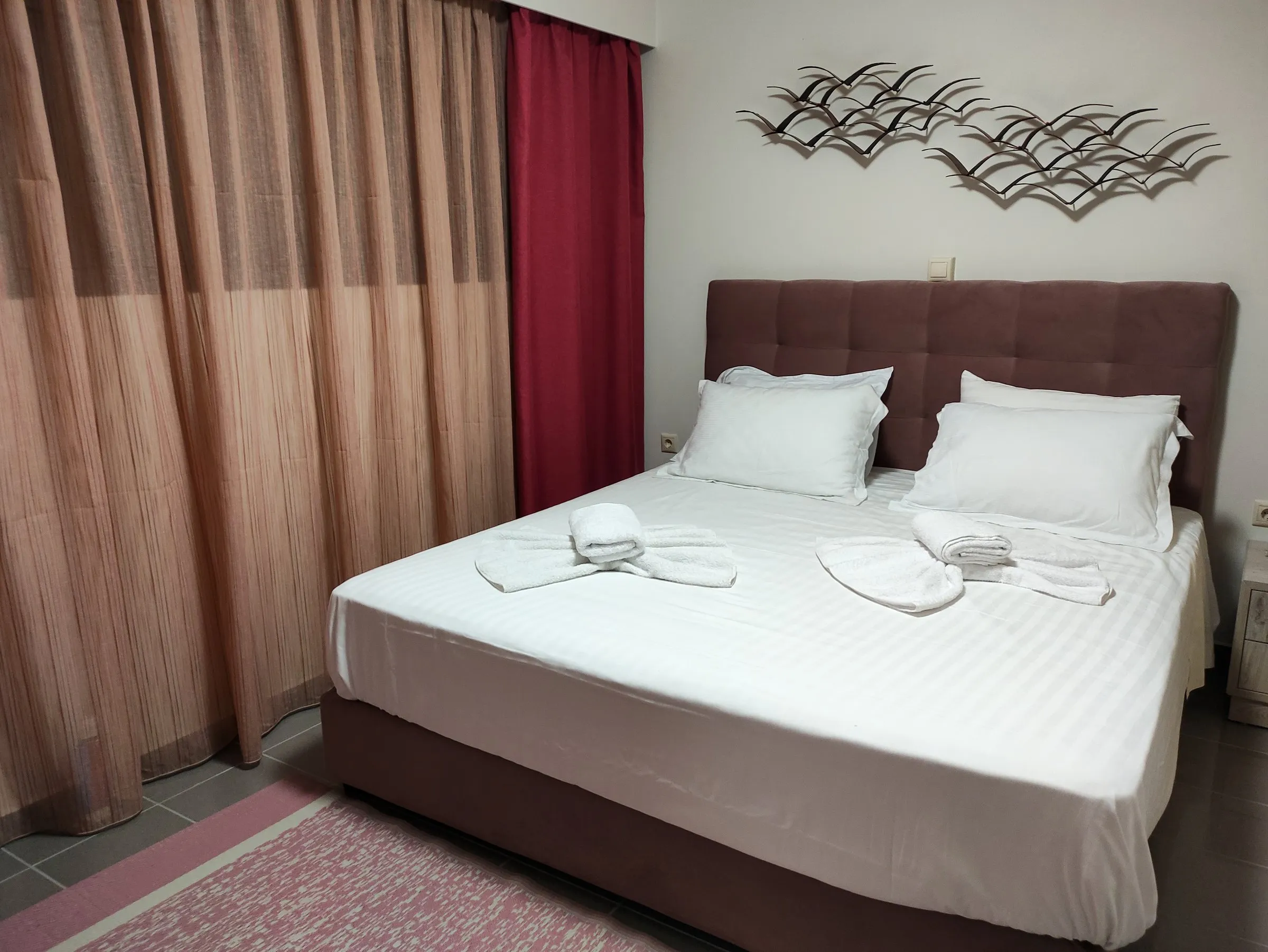 Double bed with upholstered headboard and wall sculpture